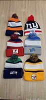 Six NFL team beanies laid out