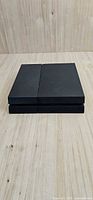 Front angled view of black PS4 console