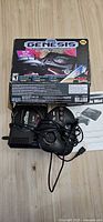 Console, controllers, power adapter, cables and manual beneath Genesis Mini box