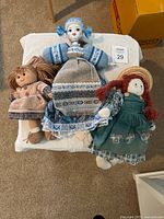Top-down view of three dolls on white surface