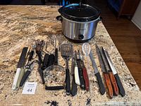 Crock-Pot slow cooker, assorted utensils and knives arranged on countertop