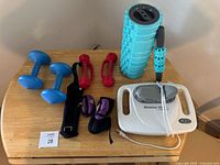 Full view of lot showing dumbbells, wrist weights, foam roller, hand roller massager, and electric Shiatsu UL massager