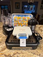 All five items grouped: George Foreman grill, Toastmaster waffle baker, food processor, stainless juicer, decorative plastic tray