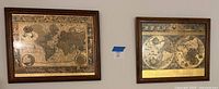 Both framed gold-tone world map prints hanging on wall
