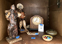 All items together inside cabinet: clock, two paper-mâché figurines, brass incense burner, woven basket, small decor
