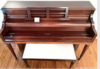 Front view of Weber upright piano with key cover closed, bench positioned in front