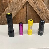 Four flashlights standing upright showing size and colors