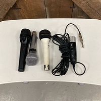 Four microphones lined on tabletop