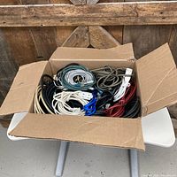 Cardboard box on table holding assorted coiled cables