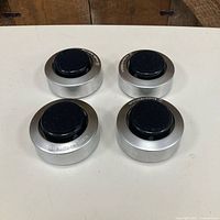 Top view of four Audio-Technica AT605 feet showing aluminum bodies and black tops