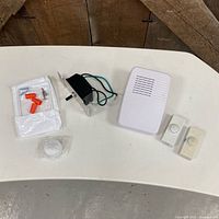 All components laid out: dimmer assembly, faceplate kit, knob, doorbell chime, two pushbuttons