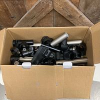 box containing assorted metal drum rack tubes and some clamps