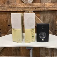 Front view of two beige Labtec speakers and one black TR speaker