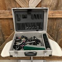 Open aluminum case showing microphone clips, windscreens, gooseneck and hardware