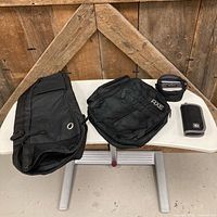 All four items laid out: long bag, Axe bag, camera pouch, Belkin case