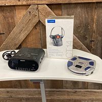 Group shot showing Sony clock, Plantronics phone box, Panasonic CD player