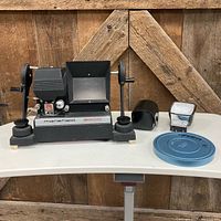 Group shot showing Mansfield film editor, film canister, flash, view finder