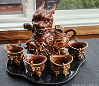 Front view of full set showing teapot and four cups on tray