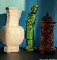 Group view of porcelain vase, green Guanyin figure and carved hardwood dragon holder