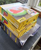 Stacked view showing two yellow Good Banana chair boxes and one Hurley snow tube box