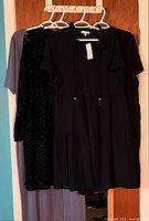 Three dresses on hangers showing styles and colors