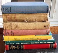 Stack of seven hardcover books showing spines