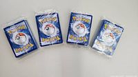 Four shrink-wrapped stacks of Pokémon cards front view