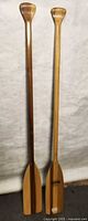 Full view of two wooden paddles standing upright