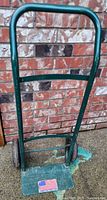Front view of green steel hand truck with wheels and toe plate visible