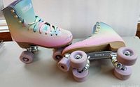 Overall view of both Impala quad skates showing pastel uppers and wheels