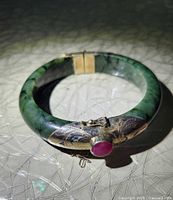 Jade bangle bracelet showing clasp end with ruby cabochon