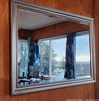 Front view of rectangular silver-frame mirror mounted on wall