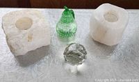 All four items: two stone candle holders, clear faceted sphere, green pear