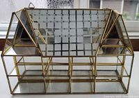 front view of brass and glass house-shaped curio with mirrored roof