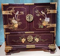 Front view showing doors, drawer, brass hardware, painted birds and flowers