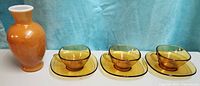 Amber glass cup and saucer sets with orange vase