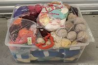Top view of clear bin filled with colorful yarn skeins and sealed bags