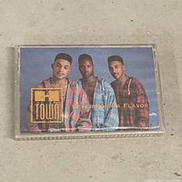Front of cassette in case showing album cover and title