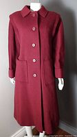 Front view of burgundy Aquascutum coat showing buttons and pockets