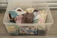 Plastic bin filled with assorted vintage baby garments