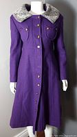 Front view of purple coat showing buttons, chest pockets and faux fur collar