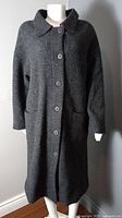 Front view of charcoal grey wool coat on mannequin showing buttons and pockets