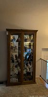 Front view of oak display cabinet with glass doors and interior shelves