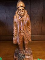 Front view of carved wooden man with hat and coat