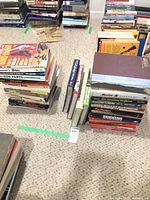 Multiple stacks of firearms reference books on carpet