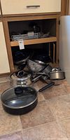 Cookware and bowls in and outside cabinet