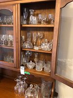 Cabinet shelves showing mixed cut glass stemware, bowls and tumblers