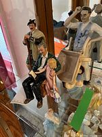 All three Royal Doulton figurines on glass shelf