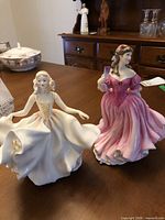 Both Royal Doulton figurines on table