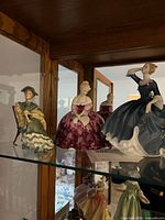 All three Royal Doulton figurines displayed on shelf